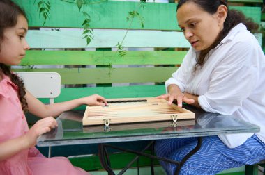 Bir anne ve kızı açık havada cam bir masada masa oyunu oynuyorlar. Bir bağ kurma, keyif alma ve bağlantı anlarını paylaşıyorlar..