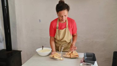 Woman carefully arranging ladyfingers for a traditional Italian dessert. Culinary preparation in cozy kitchen setting with fresh ingredients and utensils. clipart