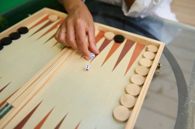 Ahşap bir tavla tahtasında el hareketli zar atmak, klasik bir masa üstü oyununda gösteri stratejisi ve eğlence..