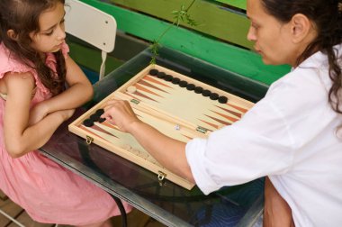 Bir anne ve küçük kızı evde tavla oynuyorlar. Aile bağları ve kaliteli zaman geçirmeleri..