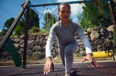 Spor giyim sektöründe kararlı bir kadın açık havada denge egzersizi yapıyor. Zindelik ve refahın altını çiziyorum, ortam güneşli bir park..