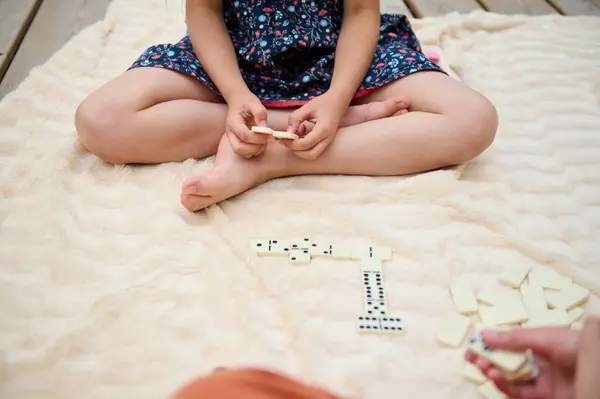 stock image A child playing dominoes on a cozy blanket, enjoying a playful and relaxing moment outdoors. The scene captures a sense of leisure and innocence.