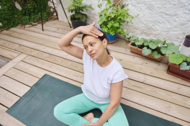 Bir kadın açık havada yoga yapıyor, yeşilliğin ortasında farkındalık ve rahatlığı teşvik ediyor. Doğal bir bahçe ortamında sağlığa ve sükunete odaklan..