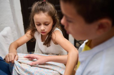 İki küçük çocuk bir objeyi birlikte incelerken merak ve odaklanma anlarını paylaşıyorlar..