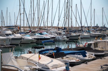 Yat ve yelkenlilerle dolu hareketli bir marina manzarası limanın sakin atmosferini yansıtıyor..