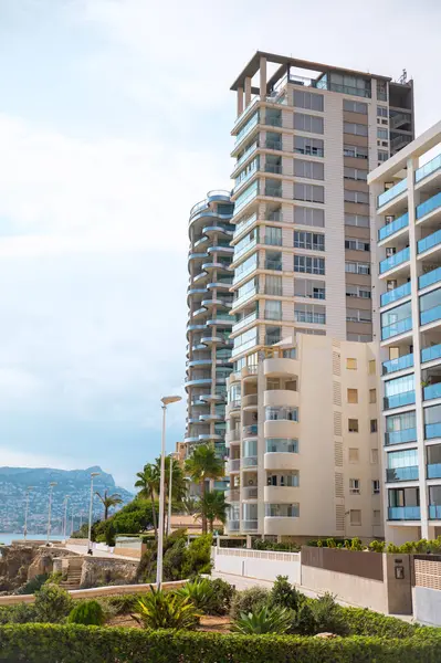 Çağdaş deniz manzaralı apartmanlar cam balkonlar, yemyeşil alanlar ve güneşli bir günde manzaralı okyanus manzarası..