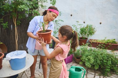 Bir anne ve kız bahçeyle uğraşır, yemyeşil bir arka bahçede saksı tutarlar. Sahne, aile bağlarını, takım çalışmalarını, doğa ve açık hava aktivitelerine olan sevgisini aktarıyor..