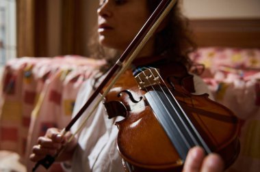 Bir insan ustalıkla keman çalar, sıcak ve samimi bir ortamda bir müzikal ifade anı yakalar. Odak noktası enstrüman ve müzikle kişisel bağlantı..