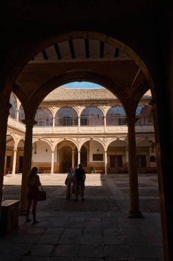 Mimari detaylar ve güneş ışığı kontrastının yer aldığı tarihi bir avlu..