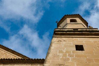 A historic stone tower extends into a vibrant blue sky, offering a contrasting view of architecture and nature. clipart