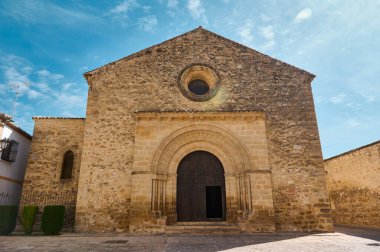Tarihi bir taş kilise, açık mavi bir gökyüzünün altında ihtişamlı bir şekilde duruyor. Karmaşık bir şekilde tasarlanmış bir kapı aralığı var. Kültürel ve tarihsel temalar için ideal antik mimari ve ruhani mirası somutlaştırır..