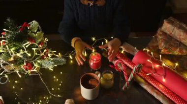 Masada ışık, şeker ve içeceklerle şenlik dekorasyonu yapan biri. Tatil ruhu..