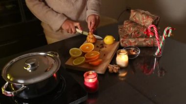 Dilimlenmiş meyveler, mumlar ve paketlenmiş hediyelerle sıcacık bir tatil sahnesi..