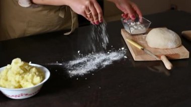 Yakın plan un serpiştirme, hamur yoğurma ve ahşap mutfak tezgahındaki malzemeler..