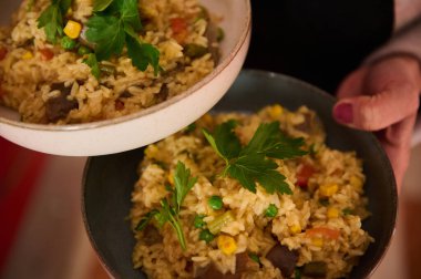 Canlı bezelyeli, domatesli ve mısırlı sebzeli paella. Maydanozla süslenmiş. İspanyol mutfak tutkunları ve vejetaryenler için ideal..