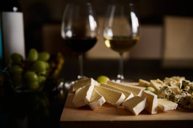 Peynir tabağı ve yeşil üzümlerin yanında beyaz ve kırmızı şarap kadehleriyle harika bir ortam yaratıyor. Aşçılık, gurme ya da sosyal temalar için ideal.