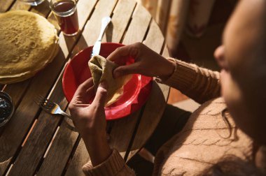 Gözleme yuvarlayan bir insanın samimi ve sıcak bir anı yakaladığı yakın çekim görüntüsü..