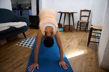 Kapalı bir yerde yoga pozu veren bir insan, sakin bir atmosfer yaratır..