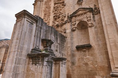 Tarihi bir taş cephesinde karmaşık mimari tasarımlar, sergilenen işçilik ve kültür mirası yer alıyor. Sahne, tarihsel derinliği yansıtıyor ve mimarideki muhafaza sanatını resmediyor..