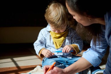 Küçük bir çocuk, annesinin eşliğinde sevgi ve destekle dolu sıcak ve samimi bir atmosfer yaratıyor..