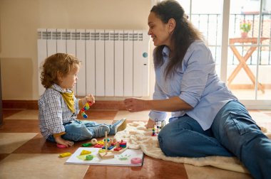 Sevgi dolu bir anne, eğitici oyuncaklarla oynarken, gelişimini hızlandırırken ve bağ kurarken küçük çocuğuyla zenginleştirici bir anı paylaşır..