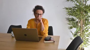 Yorgun iş kadını gözlüklerini çıkarıyor, yüzünü ve gözlerini ovalıyor. Başı ağrıyor..