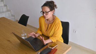 Masada oturan bir kadın uzaktan ağlıyor. Gözlüklerini çıkarır, gözlerini siler ve çalışmaya devam eder..