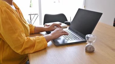 Masada Kum Saati ile Evden Bilgisayarda Çalışan Kadın. Uzak Çalışma Konsepti