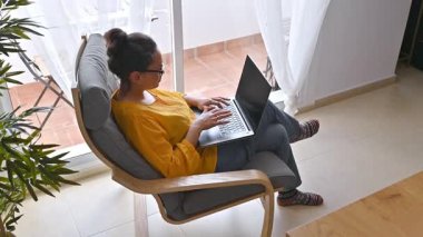 Evden çalışan bir kadın. Dizüstü bilgisayarda yazıyorum. Uzaktan kumandalı. Dijital Göçebe.