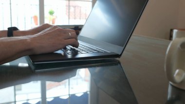 Masada dizüstü bilgisayarı olan profesyonel bir çalışma alanı. Klavyeye yazı yazan eller, temiz ve ilham verici bir ortamda teknolojiyi ve verimliliği gösteriyor..