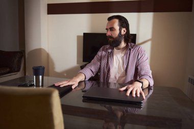 Dijital göçebe yaşam tarzını benimseyen, görevleri yöneten ve projeleri denetleyen düşünceli genç bir girişimcinin yer aldığı çağdaş bir çalışma alanı.