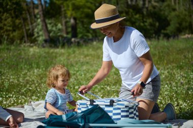 Neşeli bir kadın ve küçük bir çocuk dışarıda kaliteli zaman geçirir. Yeşilliklerle çevrili bir pikniğin tadını çıkarırlar. Aile bağını ve doğayla bağlantıyı sembolize ederler..