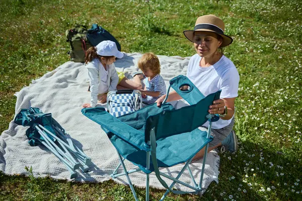 Güneşli bir günde bir aile piknik için toplanır, çiçeklerle çevrili yemyeşil bir çayırda birlikte vakit geçirirler. Arkadaşlık ve açık hava rahatlığı için mükemmel bir ortam..
