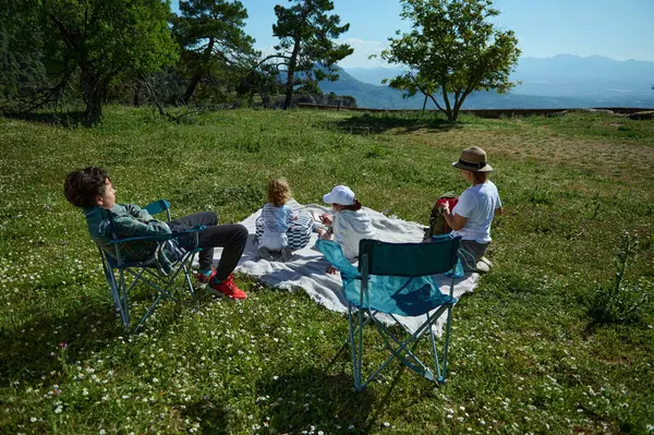 Ulusal Piknik Ayı 'nı kutlamak için muhteşem bir dağ manzarası olan sakin bir aile doğada geziyor. Paylaşılan anlar rahat ve ailevi bir ortamda dışarıda eğleniyor..
