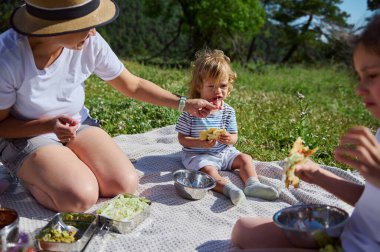 Dağlarda piknik yapmak, güneşli bir yaz gününde yiyecekleri ve açık havayı paylaşmanın sevincini yakalamak, aile ilişkilerini ve açık hava aktivitelerini teşvik etmek..