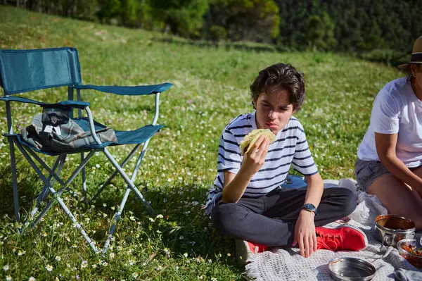 Bir aile yaz pikniğinin tadını yeşil ve güneşli ortamda neşeli ve huzurlu bir ortamda yiyecek ve rahatlıkla çıkartıyor..
