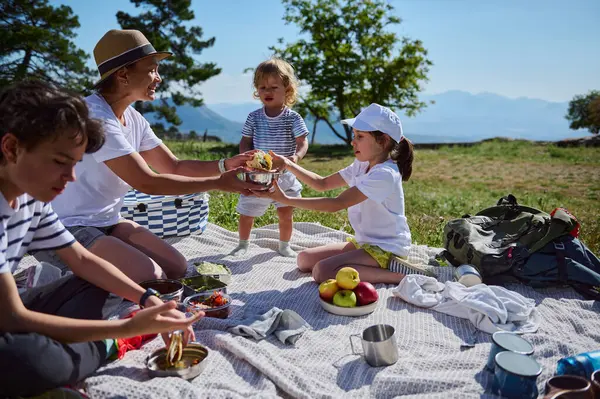 Dağlarda güneşli bir piknik sırasında aile bağları, takoları paylaşmak ve açık havayı el üstünde tutmak..