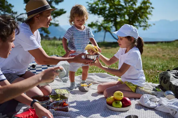 Ulusal Piknik Ayını kutlayan bir aile güneşli bir günde doğada lezzetli bir taco yemeğinin tadını çıkararak aile bağlarını derinleştiriyor..