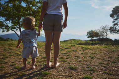 Bir anne ve çocuğunun birlikte doğayı keşfettikleri güzel bir sahne. Huzurlu bir doğal zemin arasında sevgi ve beraberlik bağı kuruyorlar. Dağ manzarası ortamı zenginleştirir.