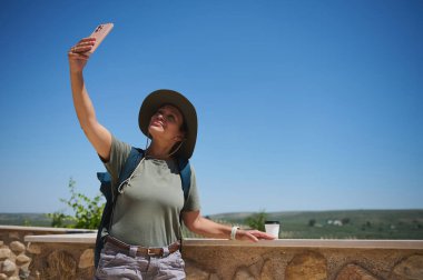 Bir birey doğa ile çevrili pitoresk bir kırsal alanı keşfederken, bir selfie ile anılarını yakalayan açık hava maceralarından zevk alır..
