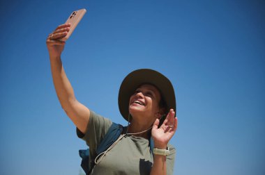 Neşeli bir maceracı canlı bir gökyüzü altında unutulmaz bir anı yakalar. Kişi neşe saçıyor ve bir keşif ruhunu kucaklıyor. Seyahat ve doğaya olan sevgisini gösteriyor..