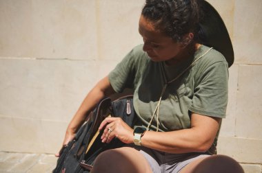 Gezgin, tarihi bir şehrin büyüleyici mimarisini keşfederken güneşli bir günün tadını çıkarıyor. Konforlu kıyafetler giymek, aktif turizm ve kültür simgelerinde merakı gözler önüne sermek.