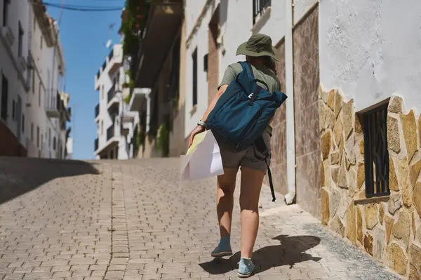 Bir gezgin, İspanya 'nın kırsal kesimlerinde kaldırım taşı sokakları olan manzaralı tarihi bir köy keşfederken bir harita, macera ve keşif titreşimleri yayıyor..