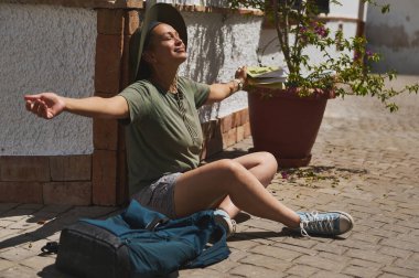 Neşeli bir gezgin, büyüleyici bir İspanyol köyünde güneşin tadını çıkarırken rahatlığı ve macerayı kucaklıyor..