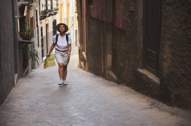 Genç bir kadın, elinde bir harita ile dar sokakları boyunca yürüyen tarihi bir kasabayı keşfediyor. Bölgenin zengin kültür ve mimarisini keşfetmekten zevk alıyor..