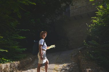 Tarihi bir kasabada gezinen bir kadın, ortaçağ mimarisi ve canlı yeşillikleri keşfediyor. Huzurlu bir taş patika boyunca seyahat ve keşif ruhunu somutlaştırıyor..