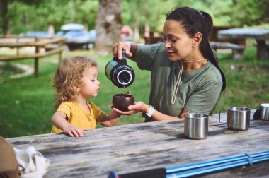 Bir anne ve küçük çocuğu dışarıda piknik yaparken birbirlerine bağlanırlar. Doğal bir park ortamında, ahşap bir masada, bir şeyler içerken bir anı paylaşıyorlar..