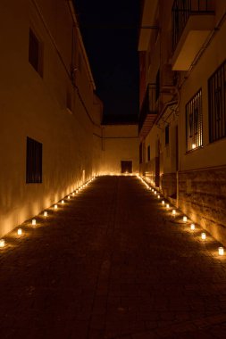 Huzurlu bir gece manzarası. Dar, kaldırımlı dar bir sokak. Eşit yerleştirilmiş mumlarla aydınlatılmış sıcak bir sıra..