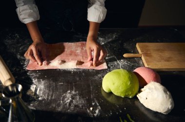 Bir şef parlak renkli makarna hamuru kullanarak ev yapımı ravioli hazırlıyor. Mutfak yaratıcılığını ve İtalyan gastronomisinin zengin geleneğini sembolize ediyor..