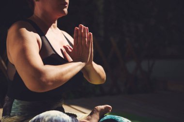 Odaklanmış bir birey, doğal ortamdaki rahatlama, farkındalık ve zindeliği vurgulayarak, dışarıda barışçıl bir yoga pozu verir..